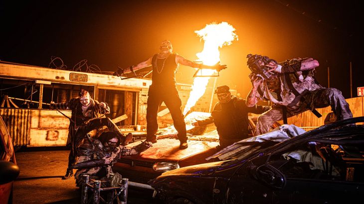 Five actors from Traumatica posing as a biker gang in a scrapyard. In the background, you can see flames coming from a flamethrower.
