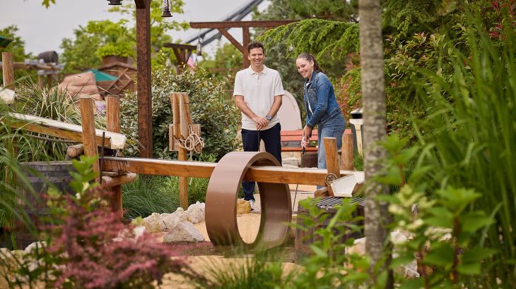 Una coppia gioca su una buca con ostacolo a loop del minigolf Gold Rush Golf di Silver Lake City.
