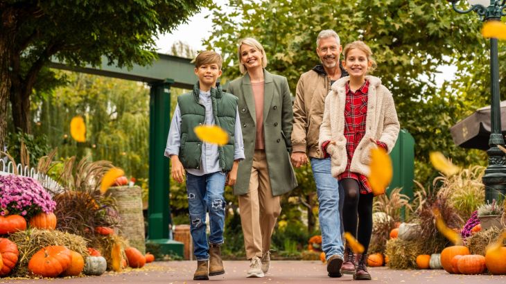 Une famille de quatre personnes se trouve dans le quartier allemand d’Europa-Park avec sa décoration automnale.