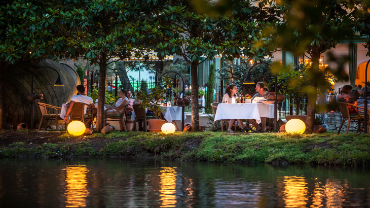 Menschen sitzen am Wasser beim Restaurant Medici