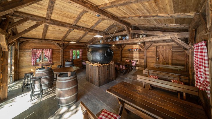 Rustikal eingerichteter Innenbereich des The Forest Kitchen im Deutschen Themenbereich des Europa-Park mit großem Kessel.
