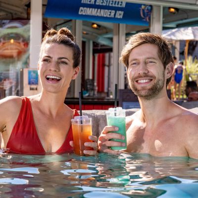 Ein Paar geniesst ihre Cocktails im Wasser