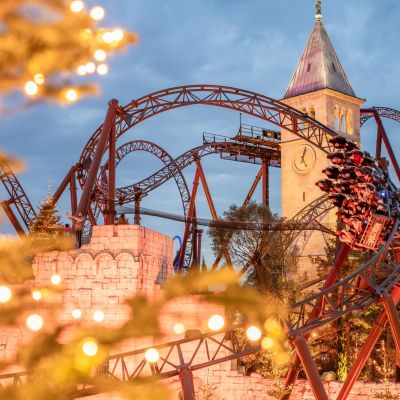 Voltron Nevera powered by Rimac fährt im Hintergrund. Im Vordergrund sieht man einen leuchtenden Tannenbaum