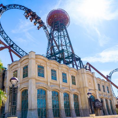 Het nieuwe stationsgebouw van Voltron Nevera in de felle zon en omringd door groene palmbomen.
