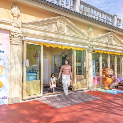 Mutter kommt mit Tochter aus dem dm family & friends Store