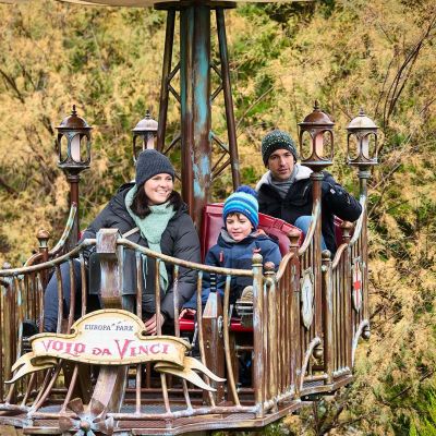 Eine Familie in einem der Fluggeräte der Attraktion Volo da Vinci.