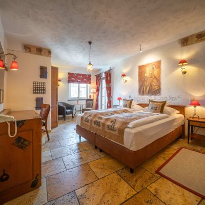 Deluxe-Zimmer mit Doppeltbett, Fernseher, Schreibtisch, Stuhl und Fenster