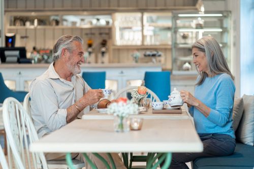 Ein älteres Ehepaar sitzt mit Kaffee an einem Tisch