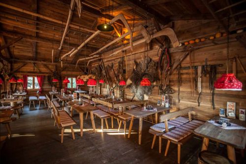 The cosy ERDINGER Hütt'n with rustic wooden benches and authentic decorations on the walls.