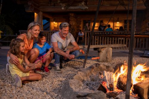 Senioren mit Enkelkindern am Lagerfeuer