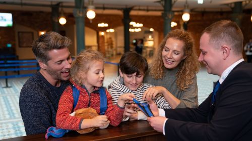 Eine Familie erhält am Eingang ihre RulaBänder.