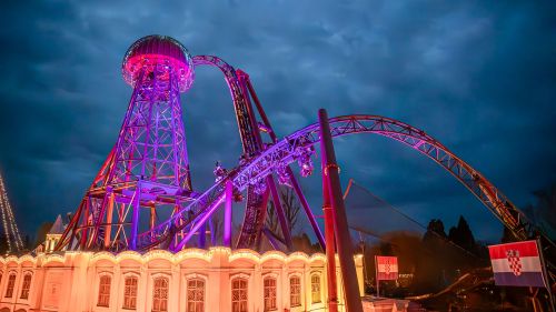 Die Achterbahn Voltron Nevera powered by Rimac in der Nacht mit pinker Beleuchtung.