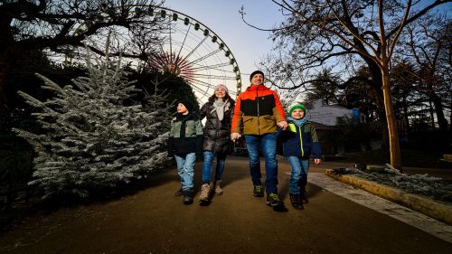 Familie läuft auf dem Weg im Hintergrund ist das Riesenrad Bellevue
