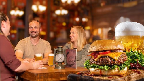 Drei Personen sitzen lachend an einem Tisch auf dem drei gefüllte Bierkrüge stehen. Im Vordergrund ist ein Burger und Bier abgebildet.