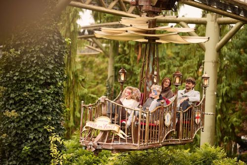 Familie bei einer Fahrt im Volo da Vinci im Italienischen Themenbereich des Europa-Park umgeben von herbstlichem Grün.