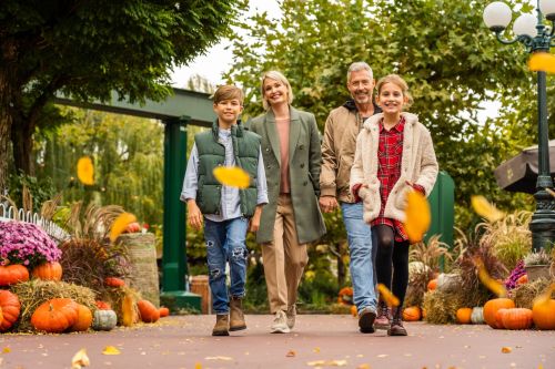 Eine vierköpfige Familie läuft durch den herbstlich dekorierten Deutschen Themenbereich im Europa-Park.