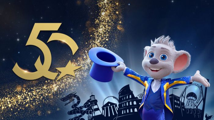Ed Euromaus in feierlicher Kleidung neben einer goldenen 50 vor der Europa-Park Silhouette.