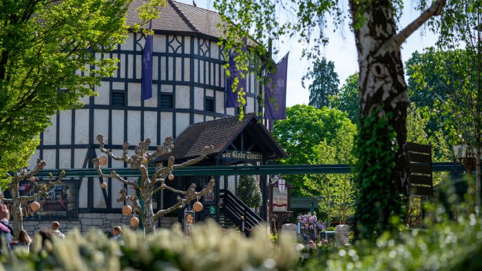 Das Globe Theater im Europa-Park liegt inmitten vieler Bäume in einer idyllischen Landschaft.