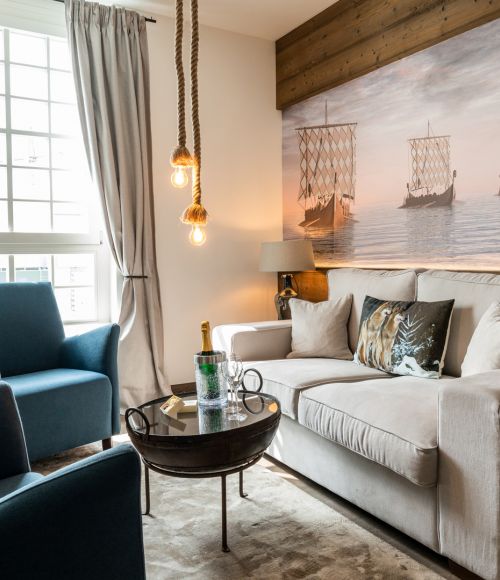 Themed suite Bluetooth in hotel Krønasår with couch, armchair and mural