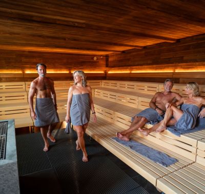 Zwei Senioren Paare sitzen in der Sauna in Rulantica Hyggedal