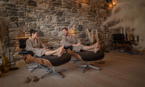 Ein Paar entspannt im Kaminzimmer im Hotel Kronasar
