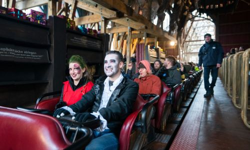 Besucher im Halloweenkostüm beim Start der Achterbahn