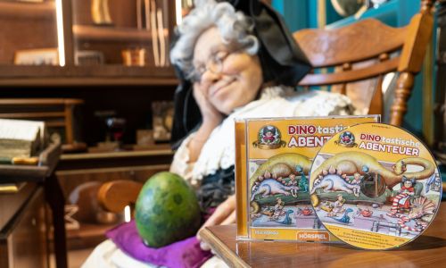 Eine Madame Freudenreich Figur, davor eine CD einer Madame Freudenreich Geschichte