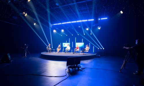 Moderierte Diskussion auf der Bühene des Streaming-Studios 4 Gäste und ein Moderator diskutieren auf der Bühne des Streaming-Studios