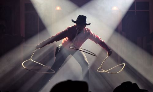 Mann schwingt im Rampenlicht zwei Lassos