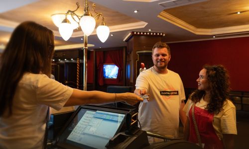 Ein Paar nimmt ihre Kinotickets im Magic Cinema 4D entgegen